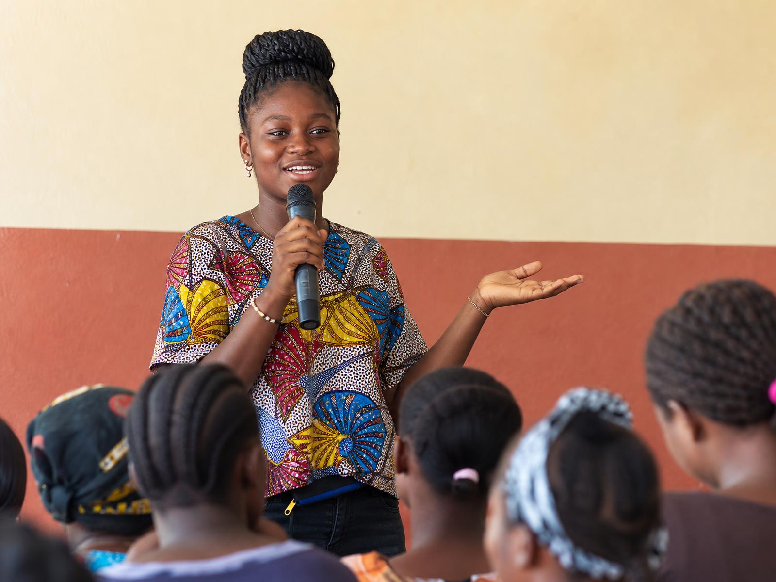 A GESL girl speaking into a microphone at an advocacy event